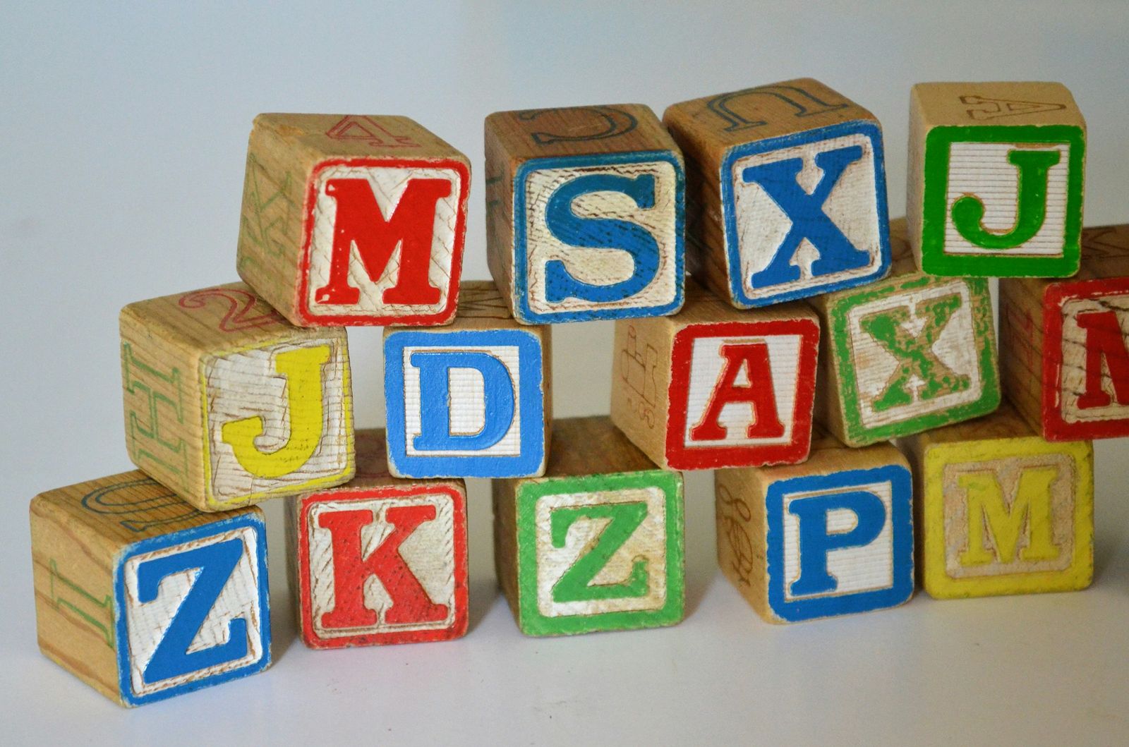 Stack of wooden alphabet blocks with coloured letters